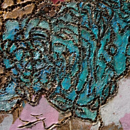 Detail of L'Électrisation du Nuage by Heather Page, an 11 13/16” square mixed media artwork of woodburned & silkscreened lichens in blue & red on a gold ground