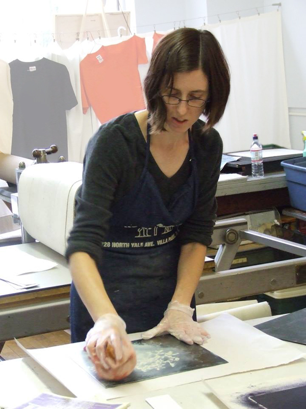Heather Page wiping an etching plate with a ball of tarletan
