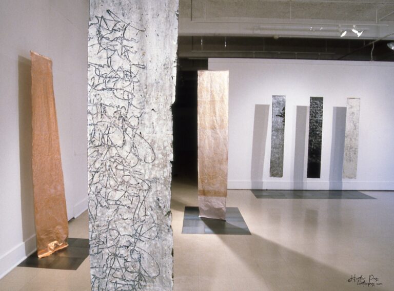 Reverb III by Heather Page, an art installation of large-scale prints on paper suspended from the ceiling of calligraphy, glyphs, and patterns found in nature