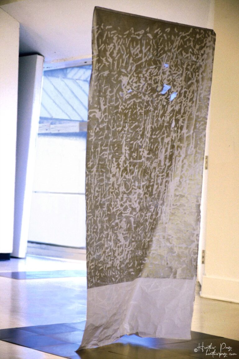Rondo by Heather Page is a 74” by 38” relief print, rubbing, and drawing on paper of calligraphic marks and looping text dancing over a dappled silver ground
