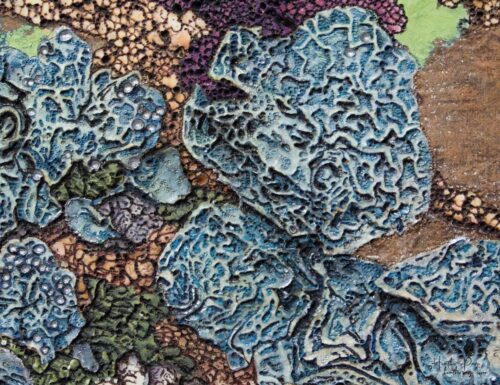 Detail of La Tempête by Heather Page, a 20” by 26” by 2” silkscreen, painting, woodburning, & collage on panel of a cluster of blue lichens on a copper ground