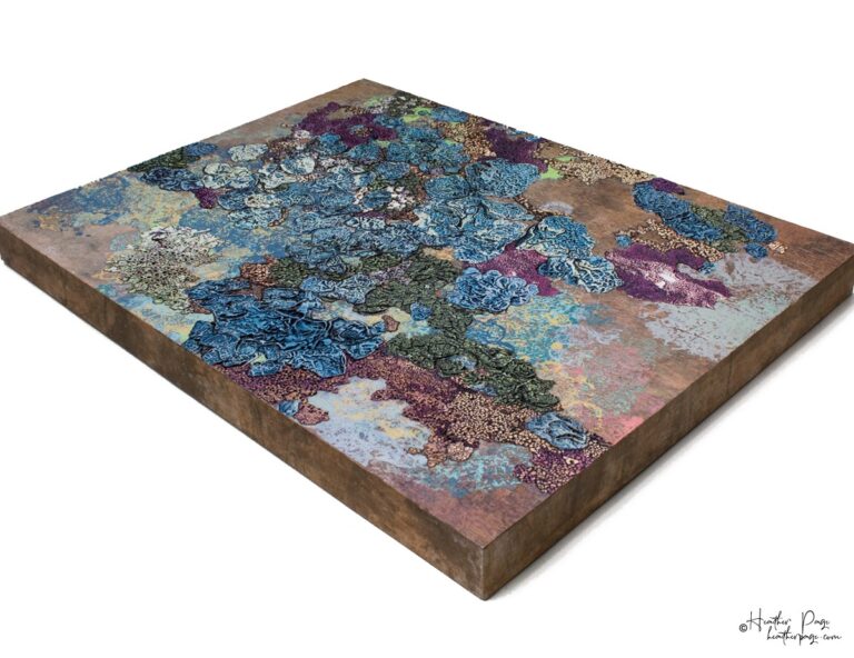 La Tempête by Heather Page is a 20” by 26” by 2” silkscreen, painting, woodburning, and collage on panel of a cluster of blue lichens on a copper background